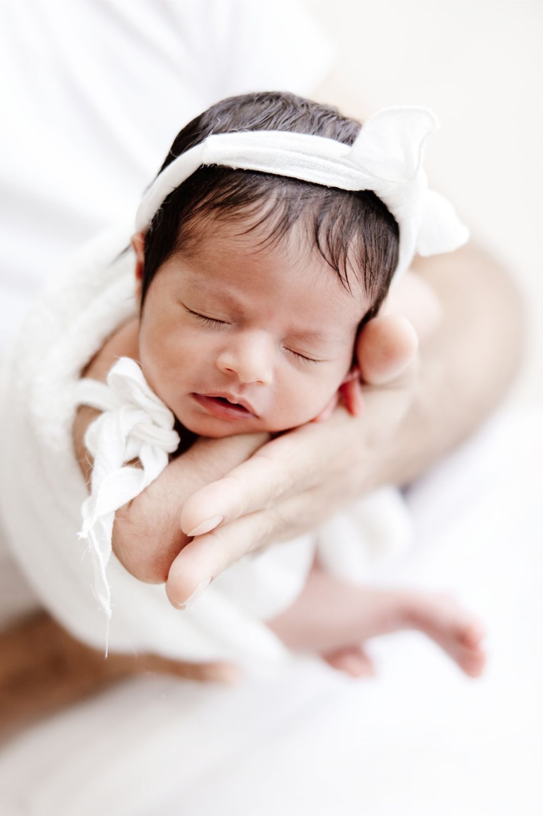 Newborn resting in her father's hand
